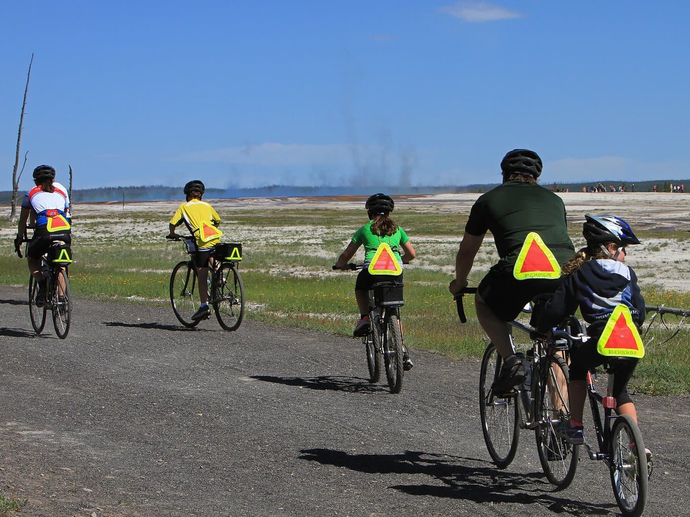 A family of five cycling together on a trail in Yellowstone National Park
